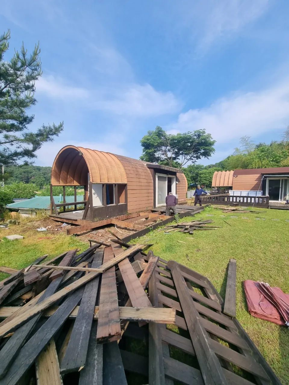 농막철거견적 현장 참고사진 - 데크 해체 후 쌓인 목재와 이동식주택